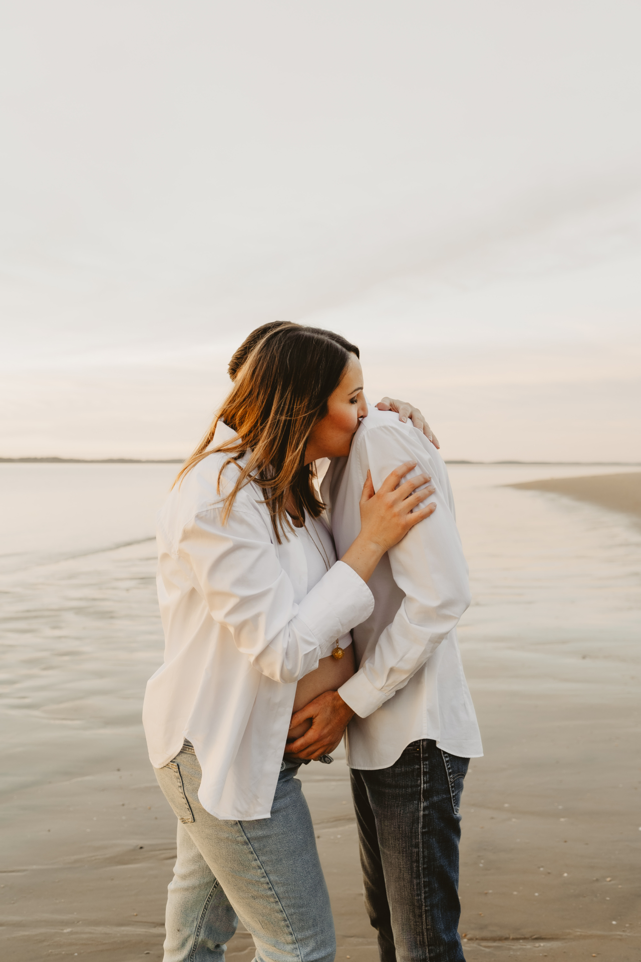 Mains entrelacées du couple sur le ventre arrondi de maman