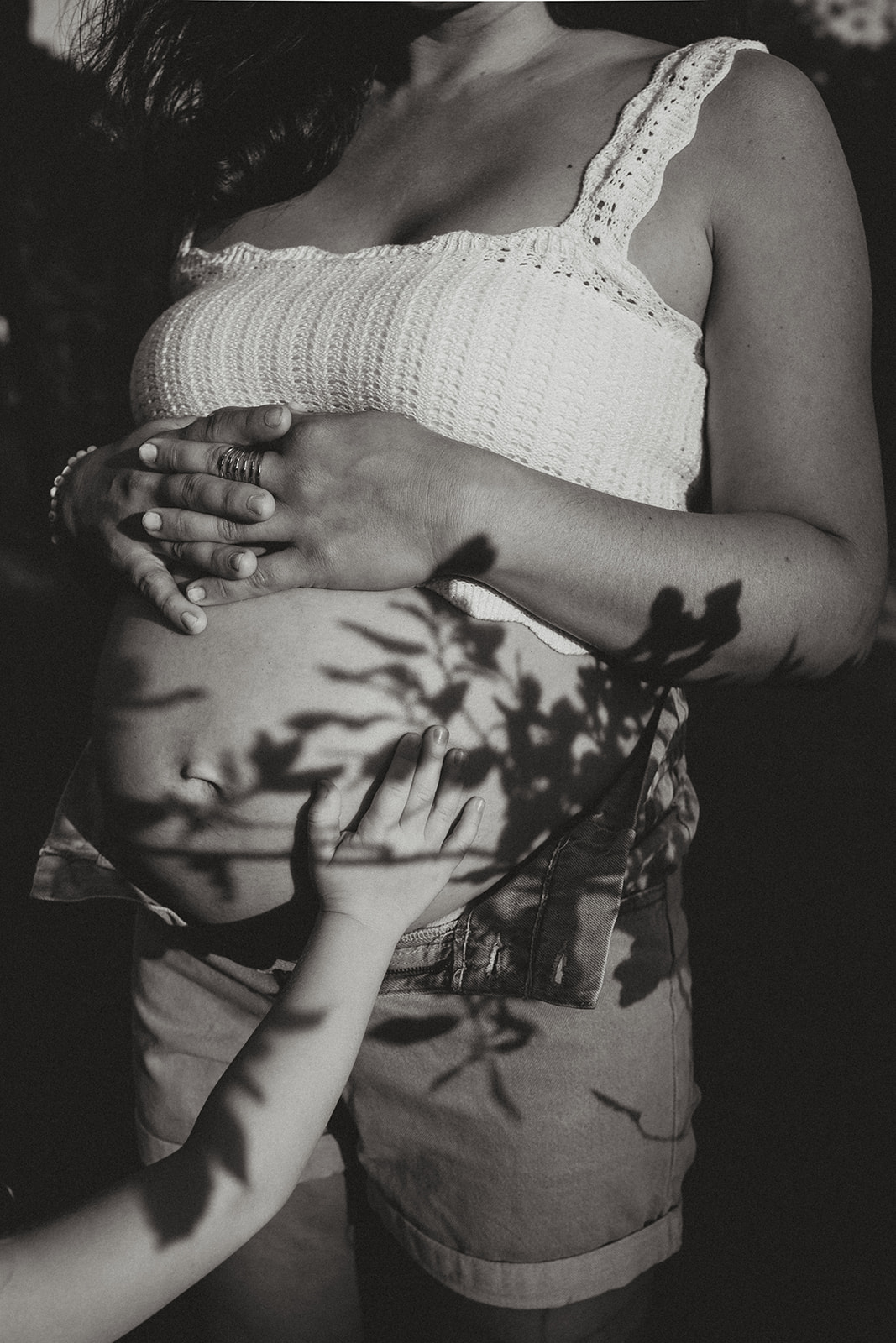 Ventre rond en gros plan, mains délicates posées dessus