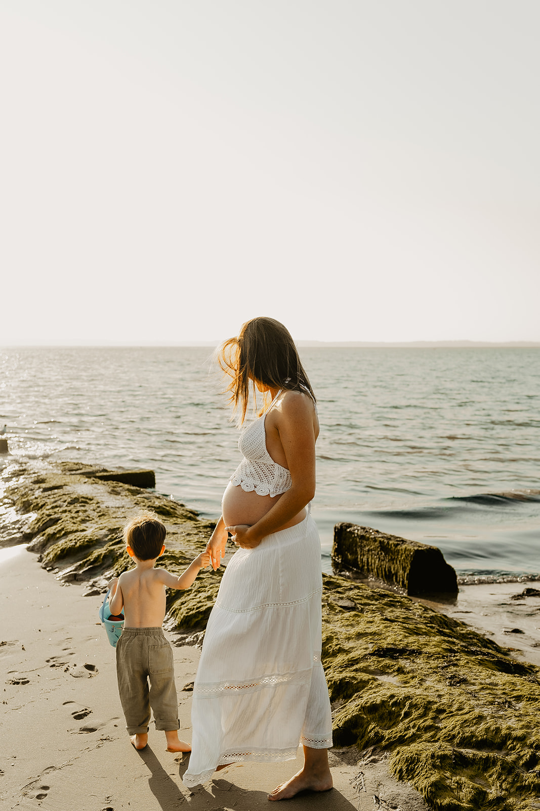 Papa embrassant le ventre de maman pendant la séance maternité