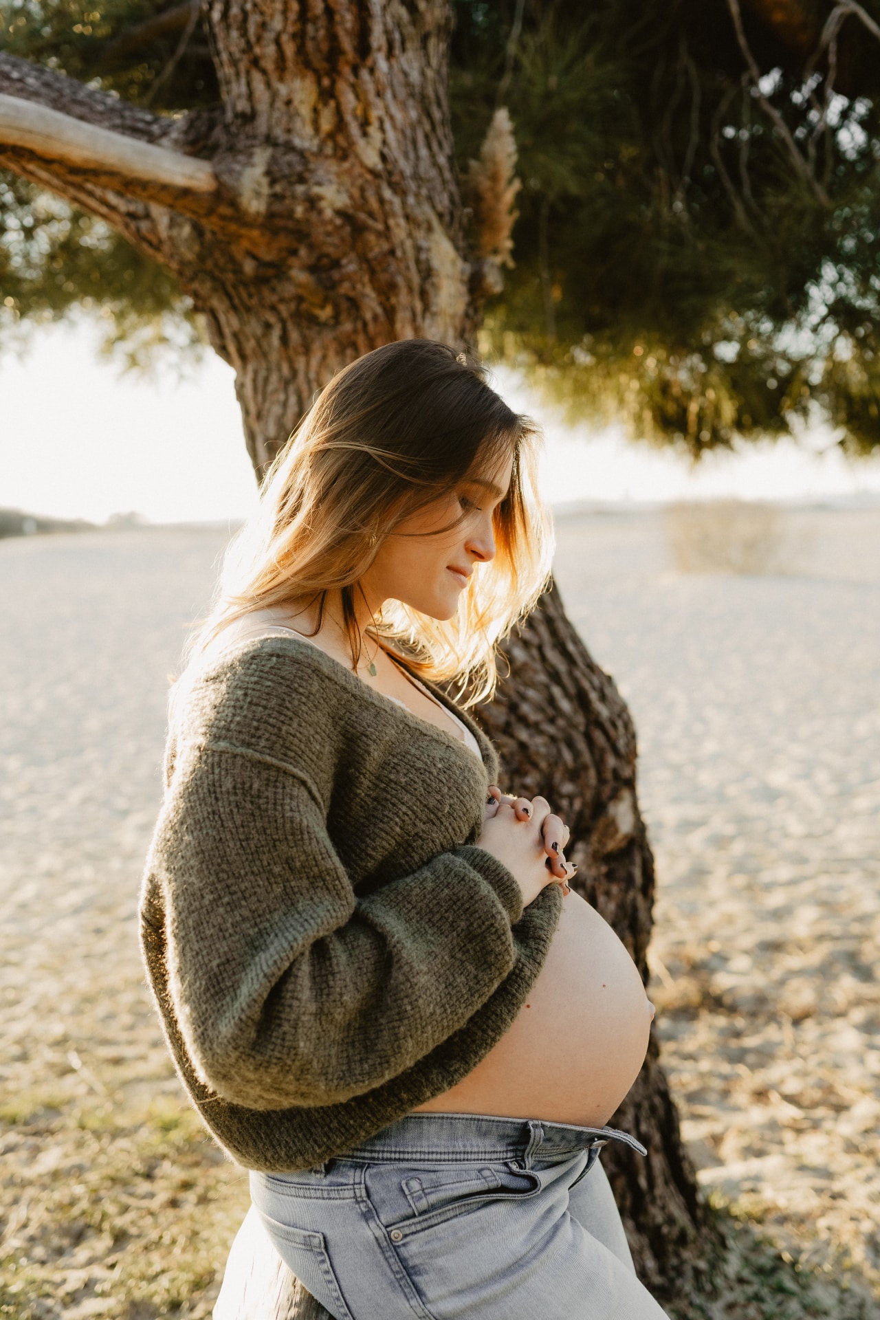 Couple attendant bébé, mains posées sur le ventre rond